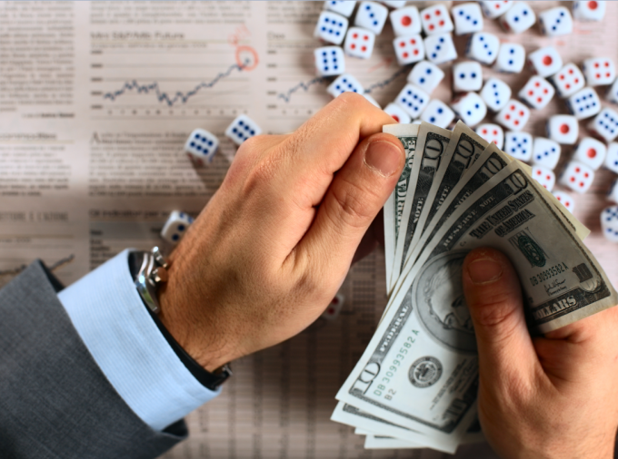 closeup of hands with cash and dice