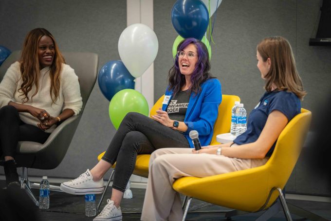 A speaker smiles during a panel presentation.