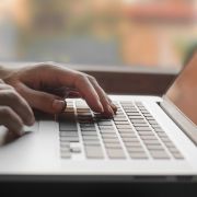 Close up of individual typing on laptop