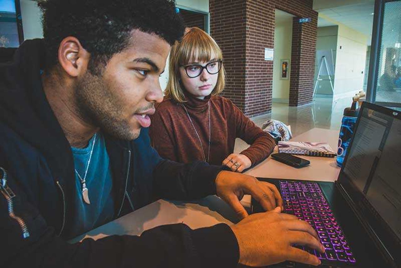 Tutor and student using laptop computer