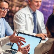 Administrators and medical professionals at a table with computers