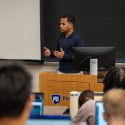 An alum speaking to students in a classroom.