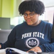 Woman reading a book in front of computer