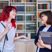 Teacher or counselor speaking with high school student.