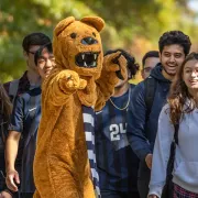 Penn State Nittany Lion mascot with students on a tour of campus.