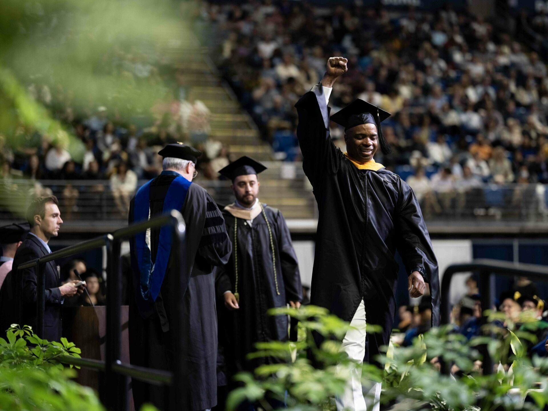 Graduate student walking across the stage at Commencement