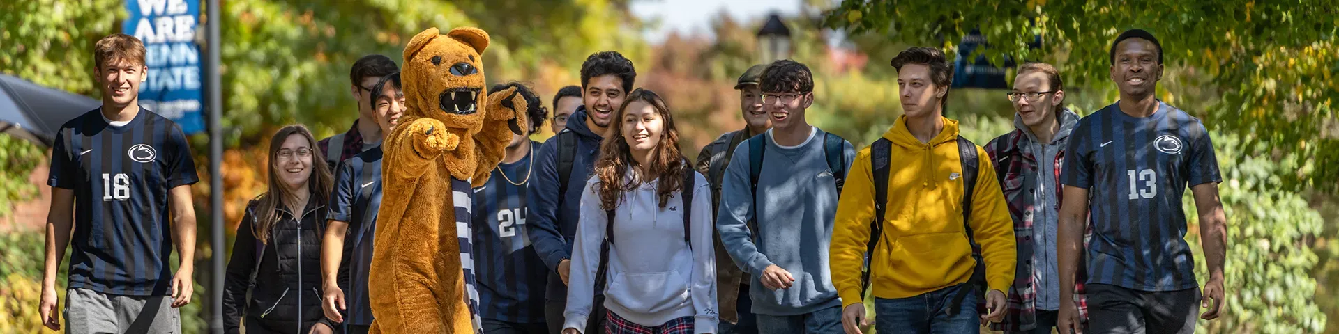 Penn State Nittany Lion mascot with students on a tour of campus.