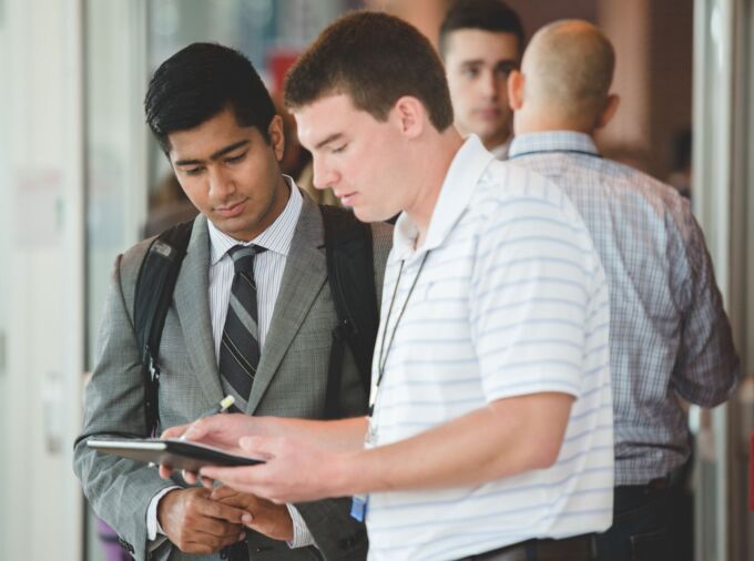 A student and employer interact at a career fair.