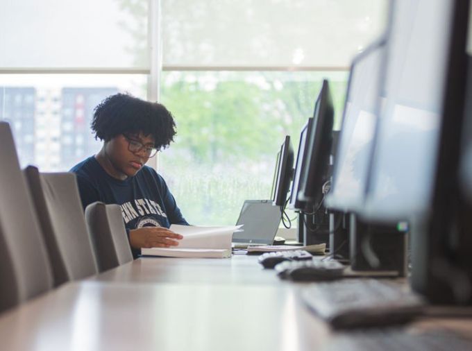 Student reading book at computer lab