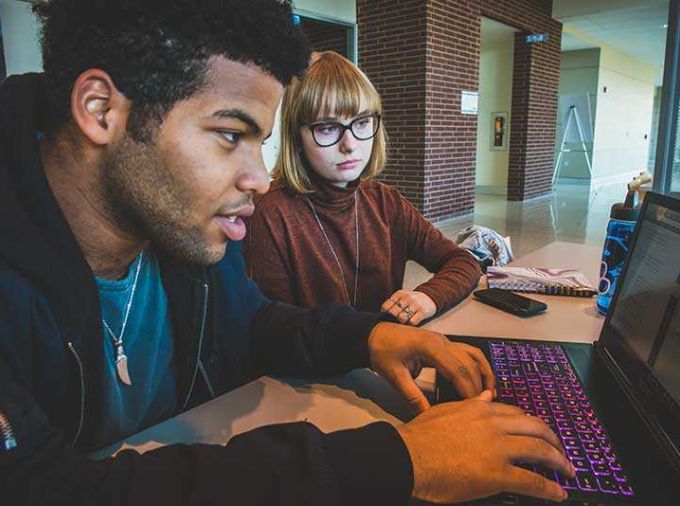 Tutor and student using laptop computer