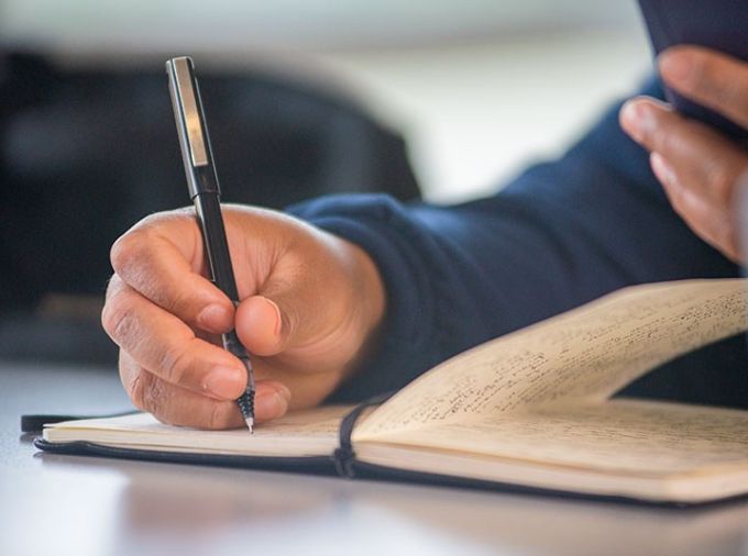 Student writing in a notebook