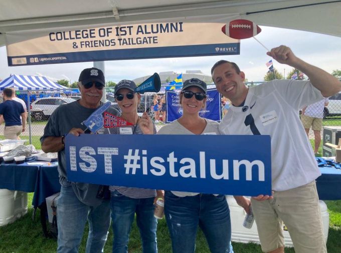 Alumni celebrating at a football tailgate.