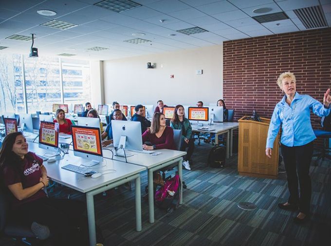 Teacher instructing a class of students in a computer lab