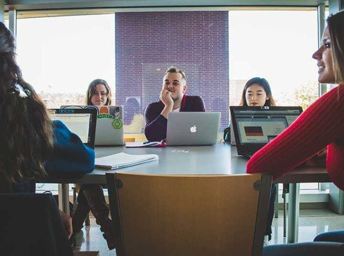 Students with laptops at table