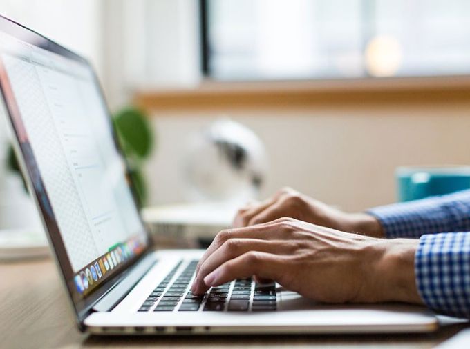 Handings typing on a laptop keyboard