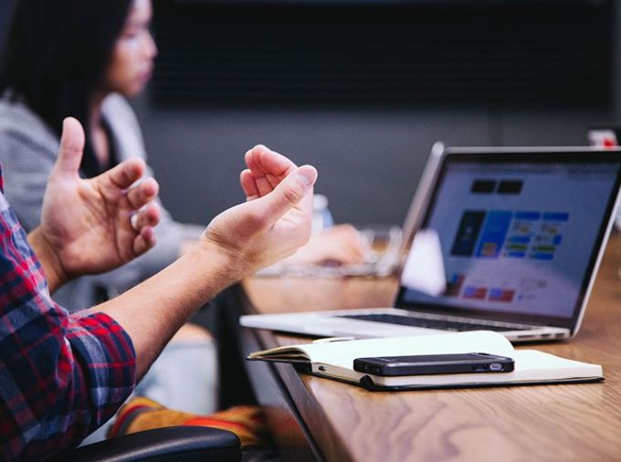 Person showing hands in front of laptop