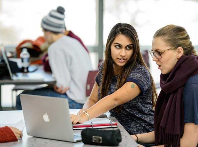 Two female students working on a laptop