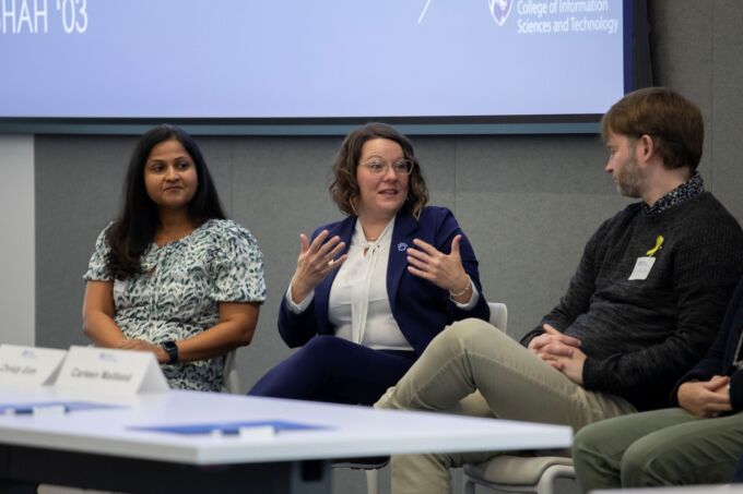 A person speaks as part of a panel presentation.