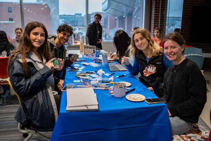 Students smile at a table.