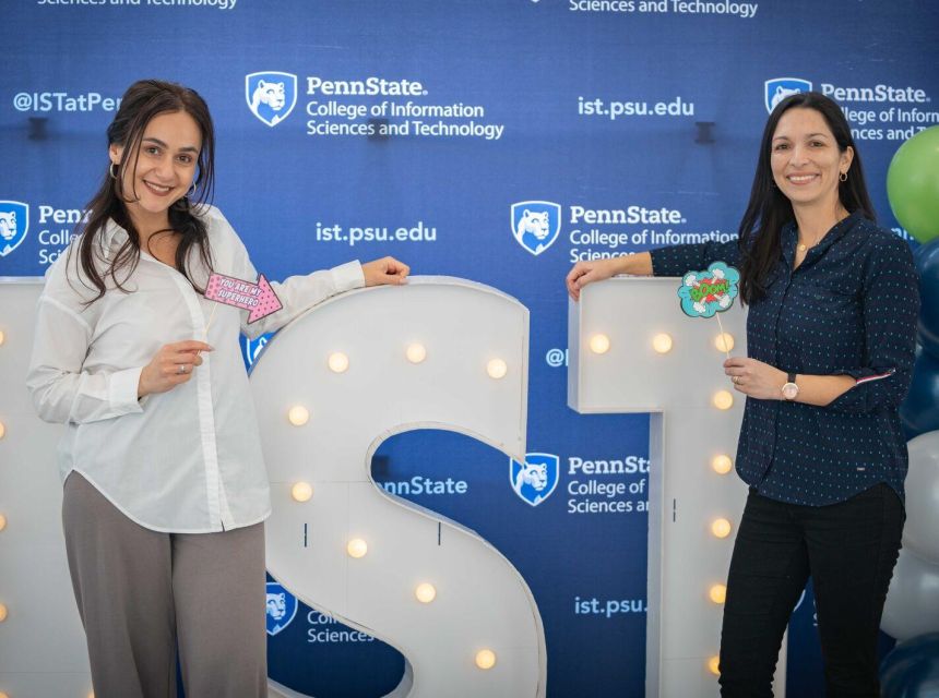 Students smiling in front of IST block letters