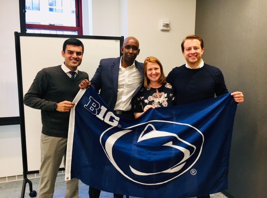 Young professionals holding a Penn State flag