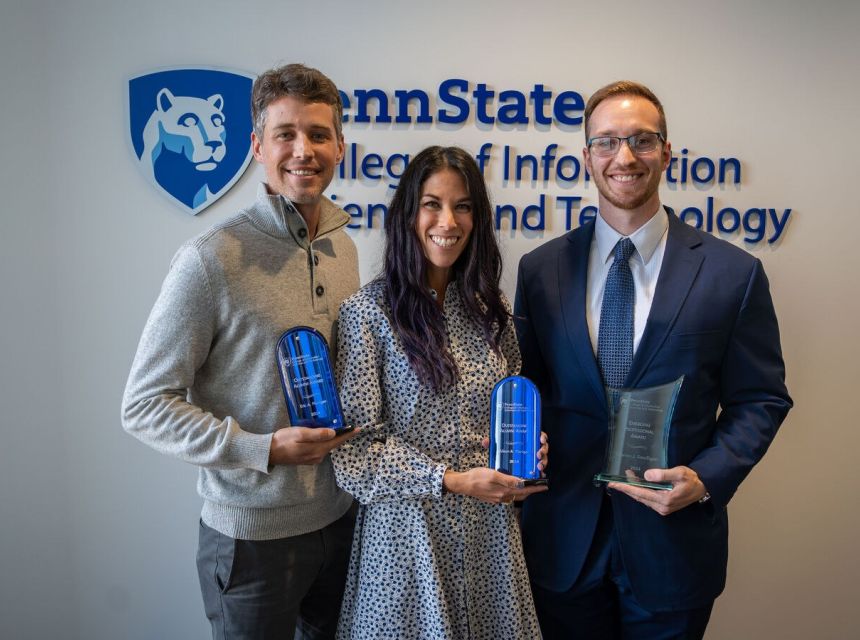Alumni award recipients pose with their awards.