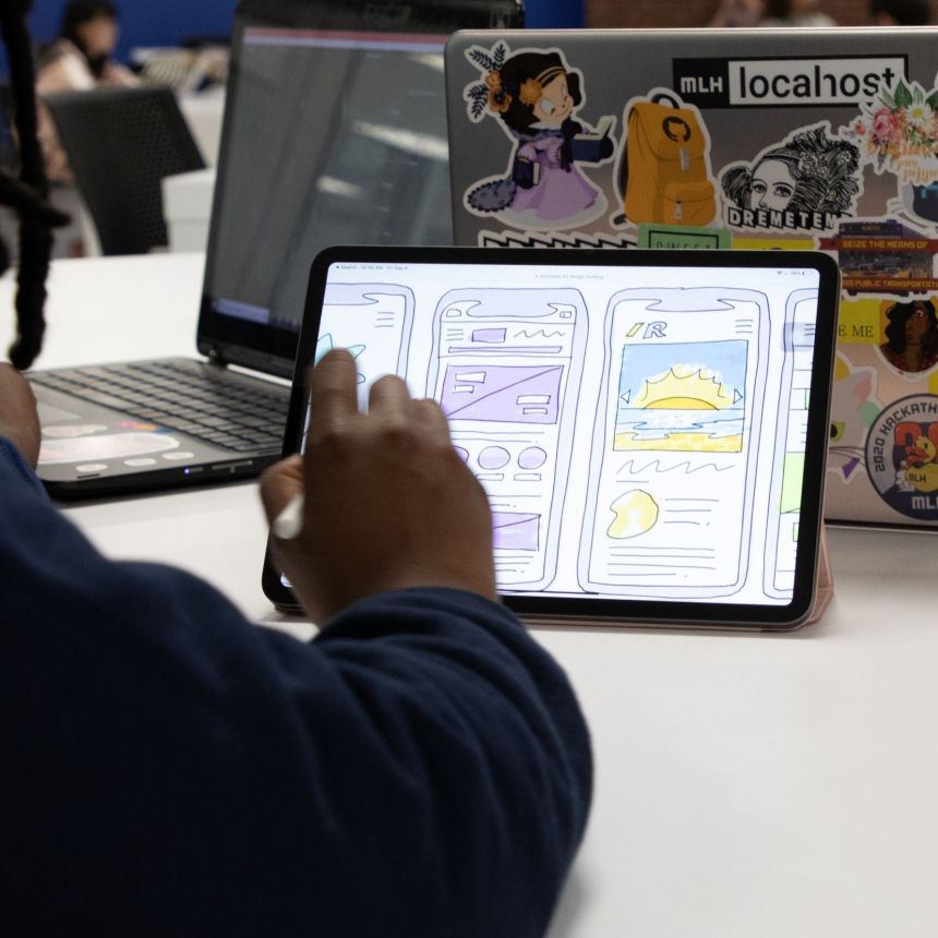 A closeup of a student wireframing a mobile application on a tablet.