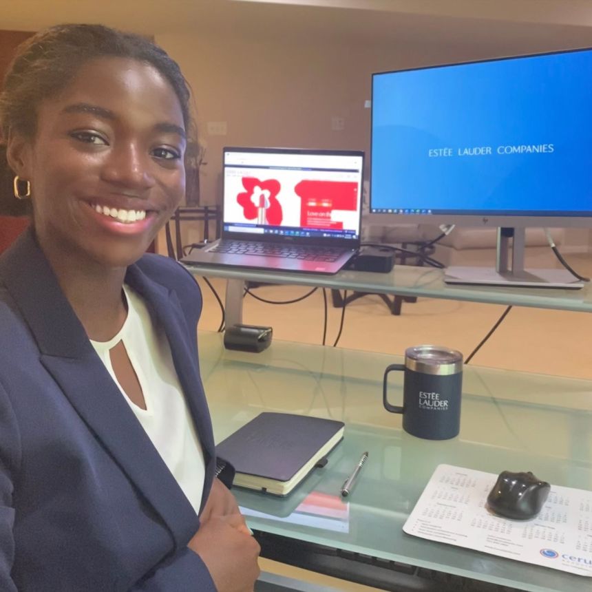 A smiling student at a computer.