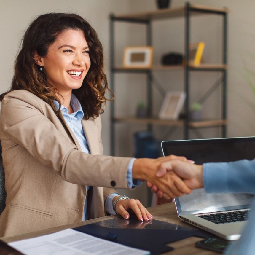 People shaking hands in a professional setting.