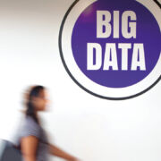 Blurry student shot in time-lapse in front of a sign that reads Big Data