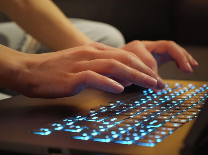 Closeup of hands typing on a keyboard.