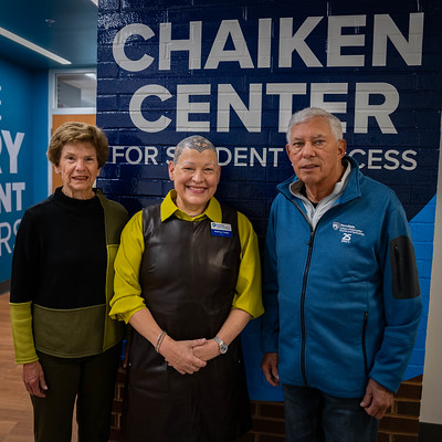 three people standing in front of brick wall