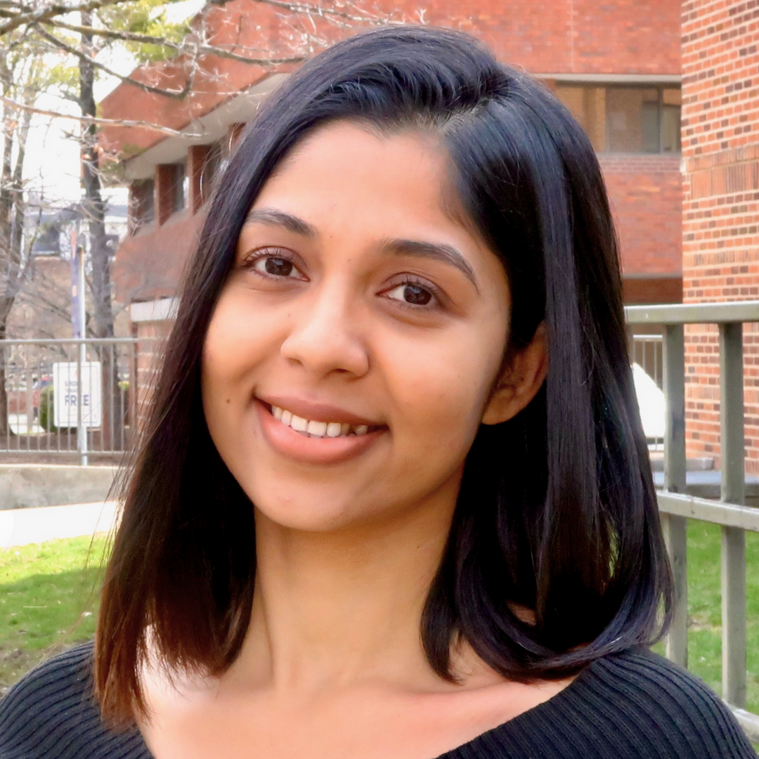 smiling person with shoulder-length dark hair